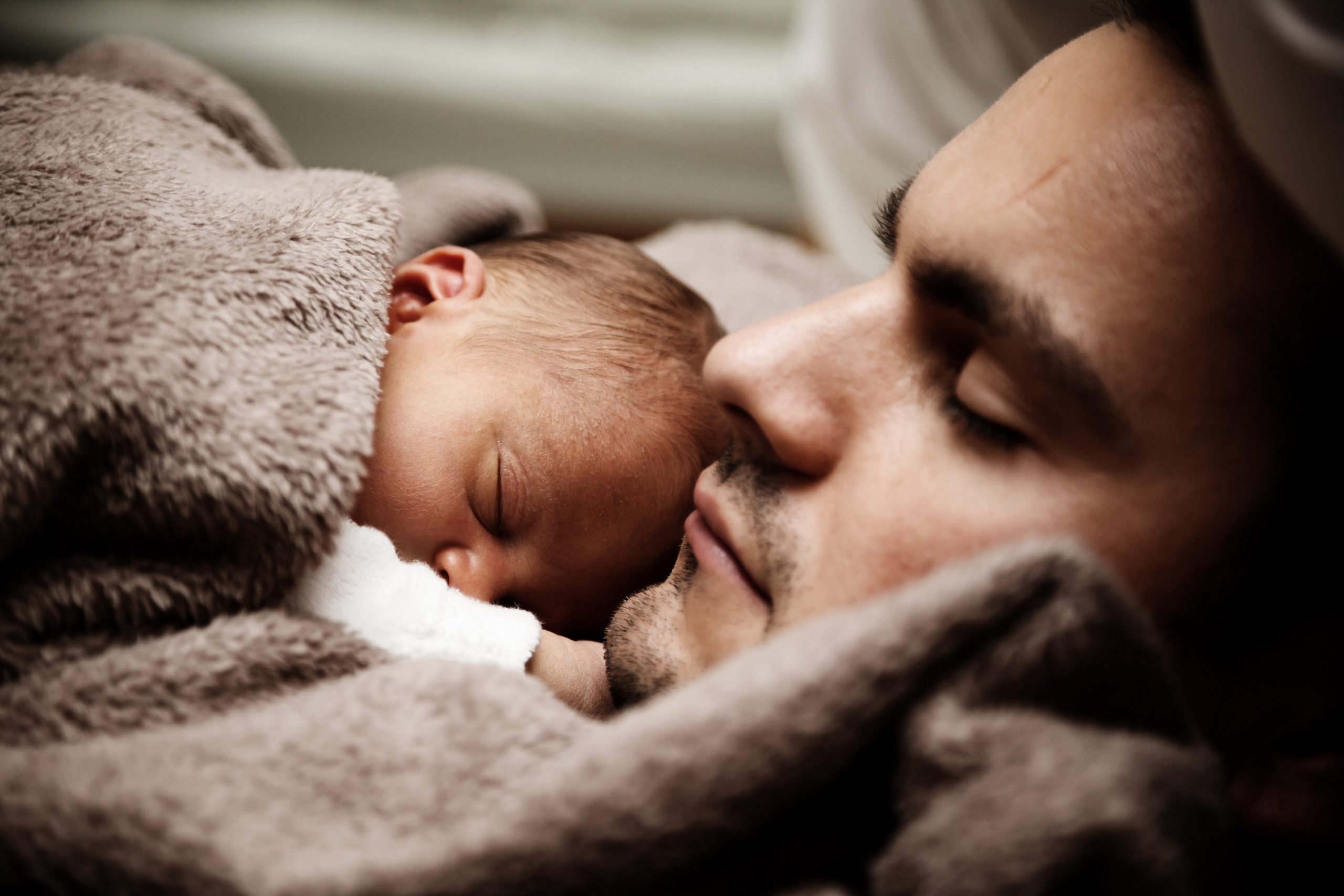 sleeping postpartum parent with baby