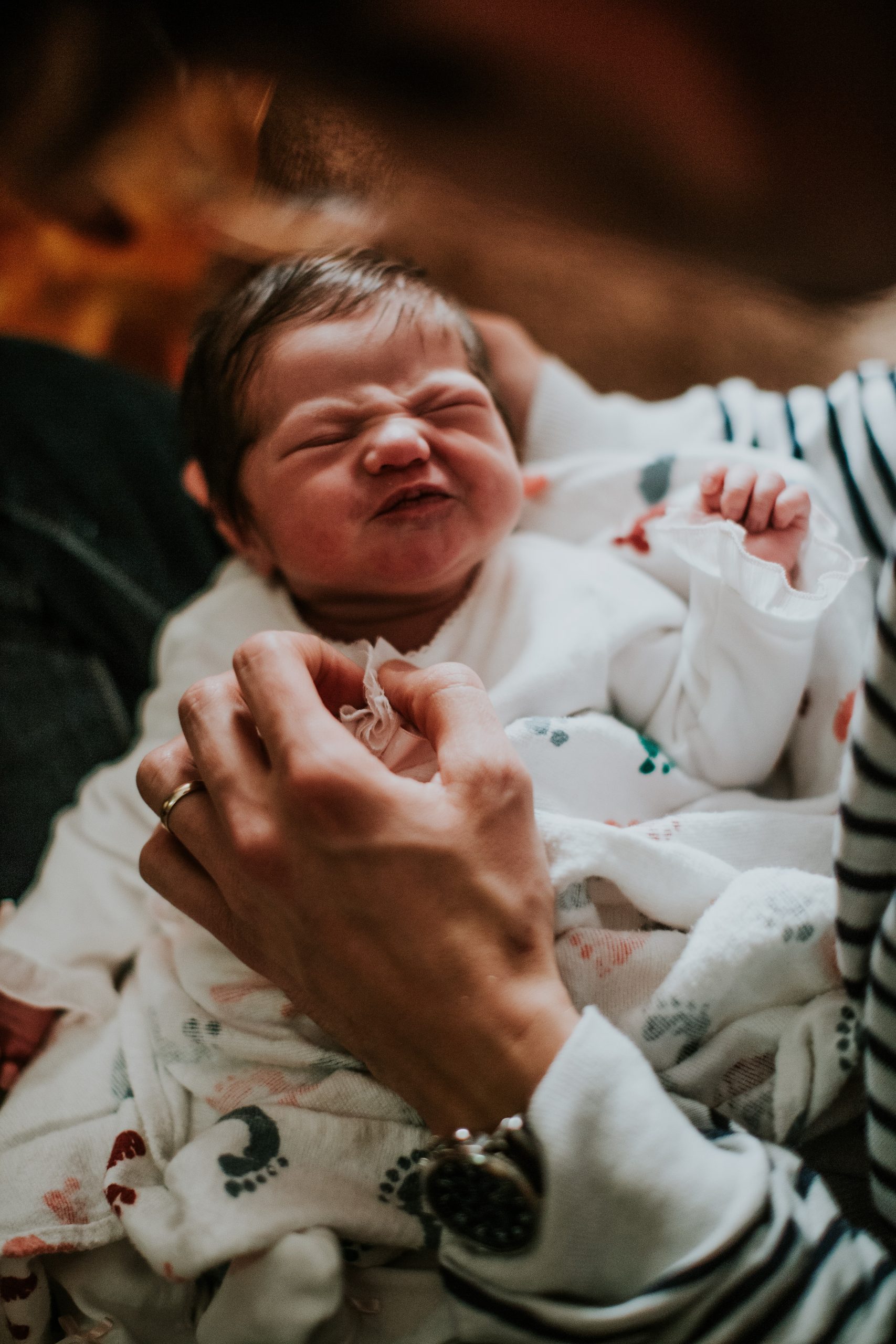newborn being held by postpartum parent during covid-19