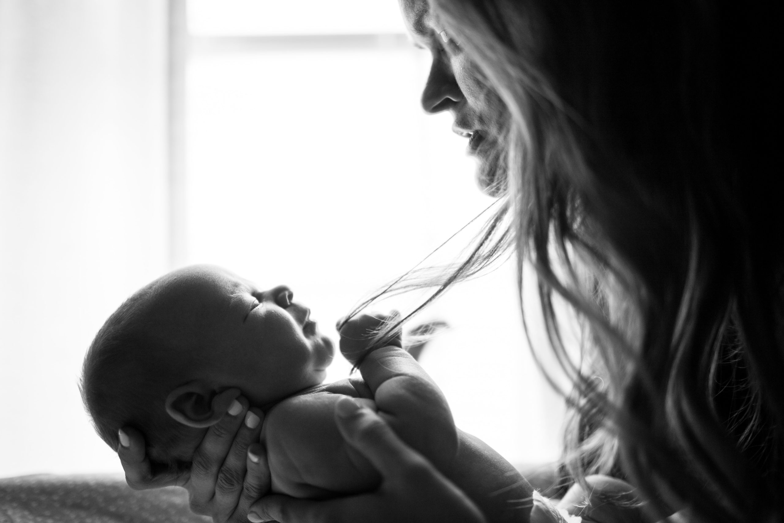 black and white photo of a newborn support person holding baby