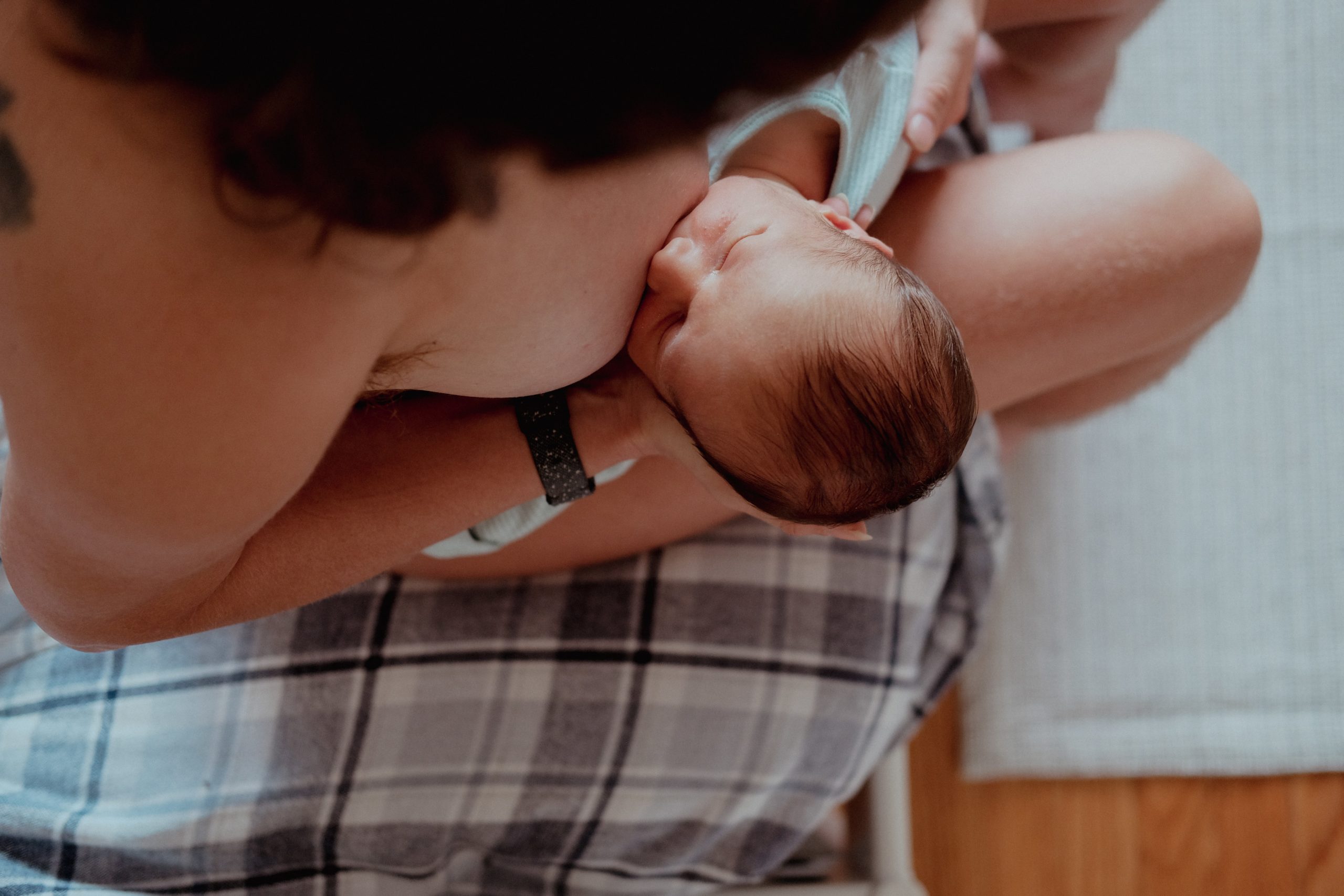 parent holding baby in their arms as they bodyfeeding
