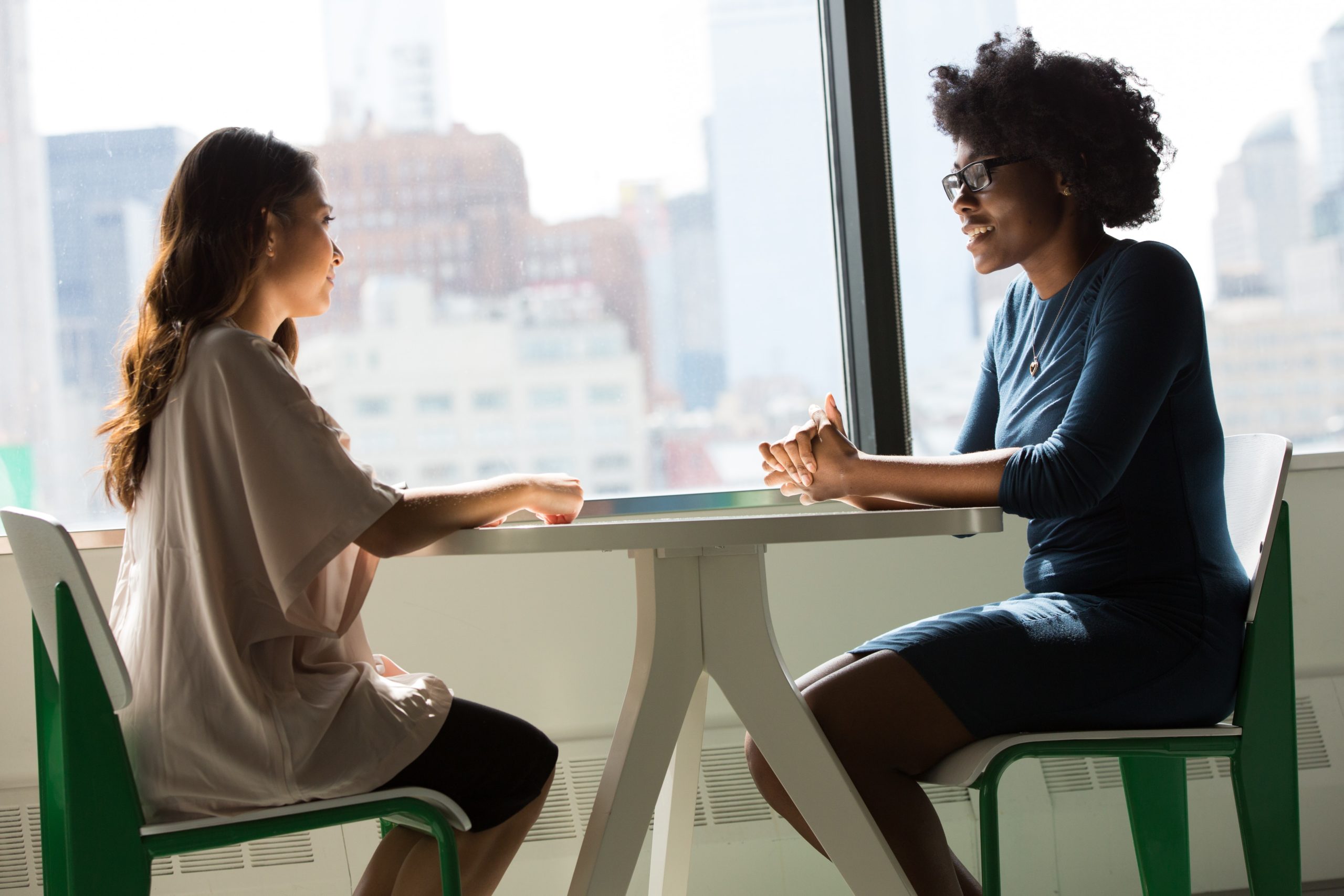 pregnant person and doula sitting together at table