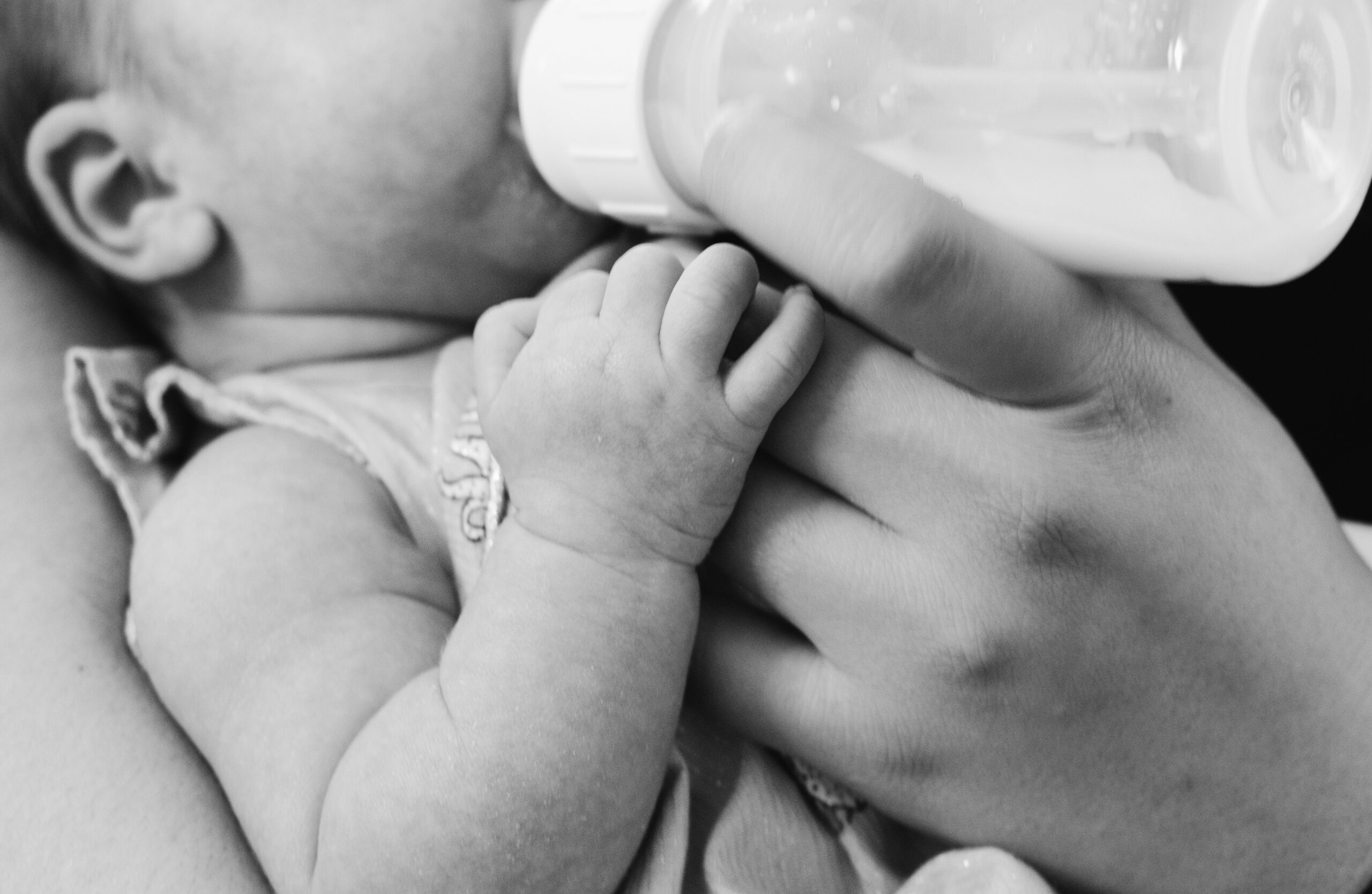 closeup of parent using paced feeding with their newborn.