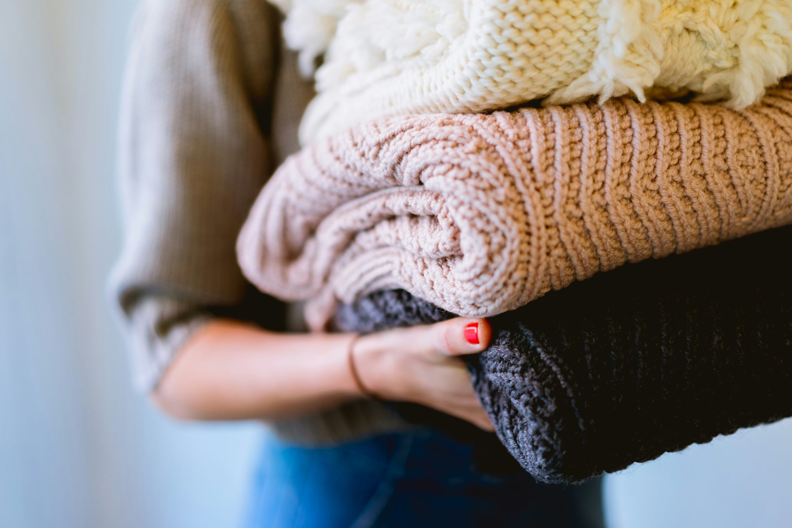 Person holding clean laundry in a stack.