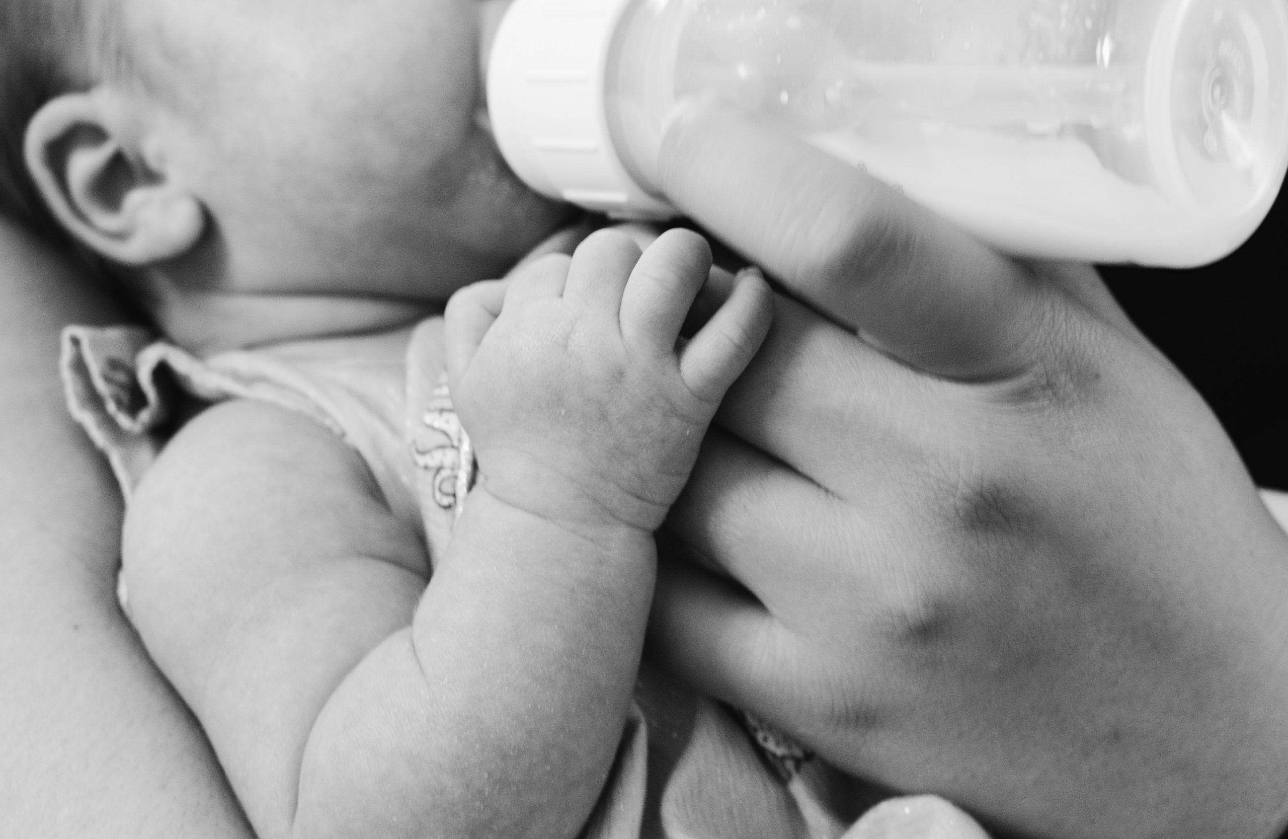 postpartum doula feeding a baby a bottle.