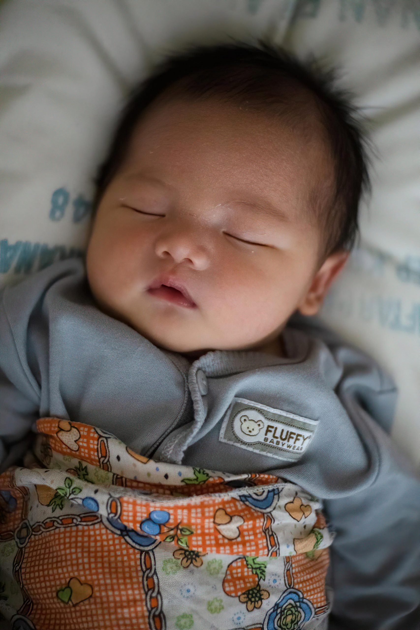 baby in swaddle and sleeper, sound alseep.